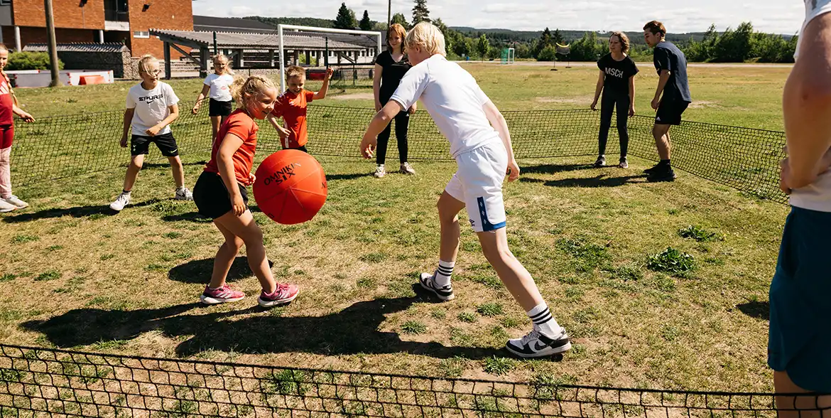 Barn som spelar gagaball utomhus på skolgården.